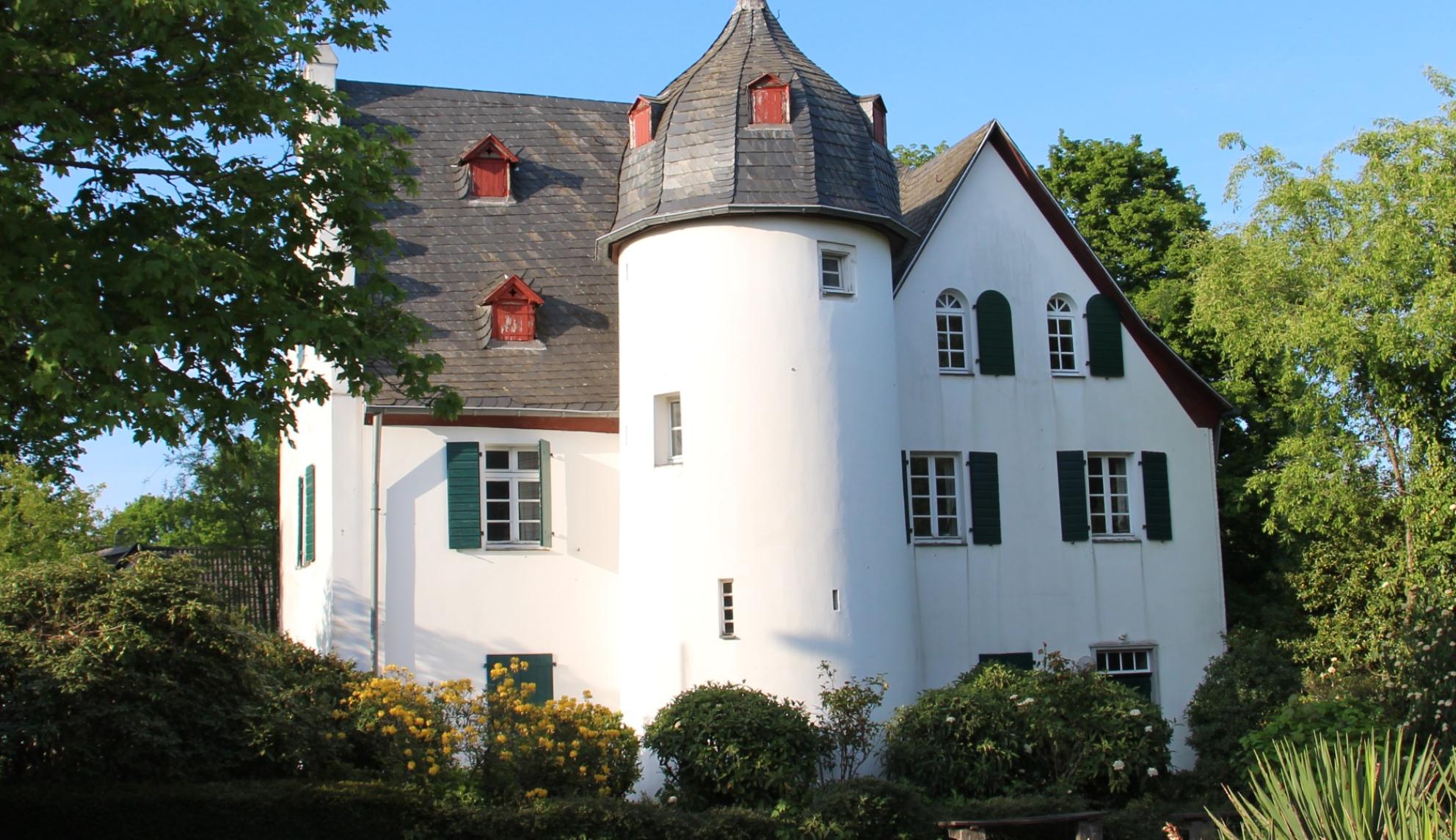 Friedenberger Hof mit Bäumen und blauem Himmel