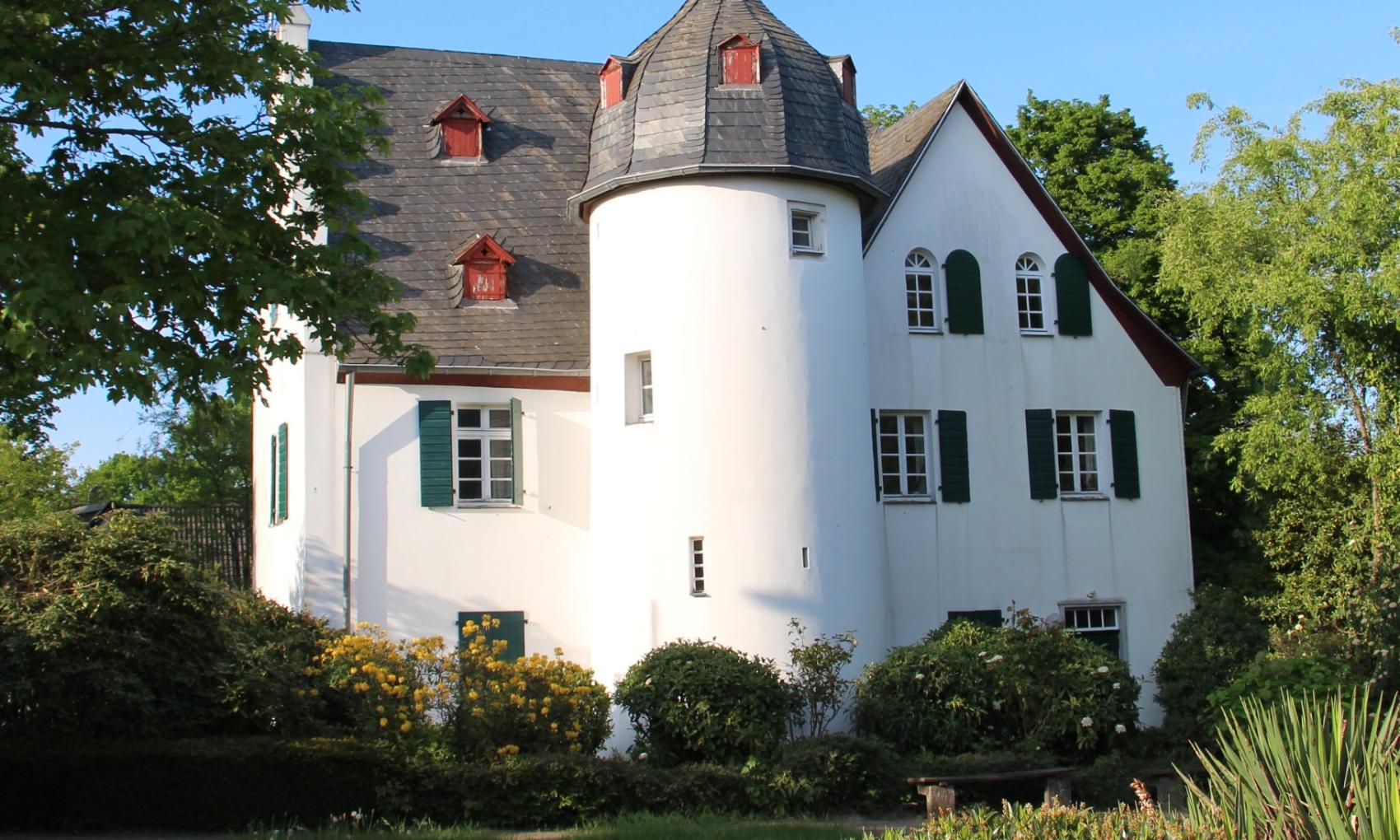 Friedenberger Hof mit Bäumen und blauem Himmel