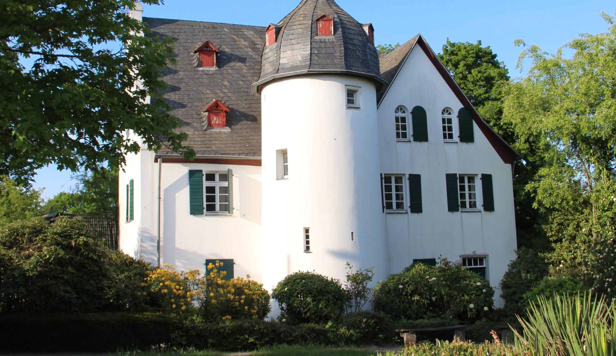 Friedenberger Hof mit Bäumen und blauem Himmel