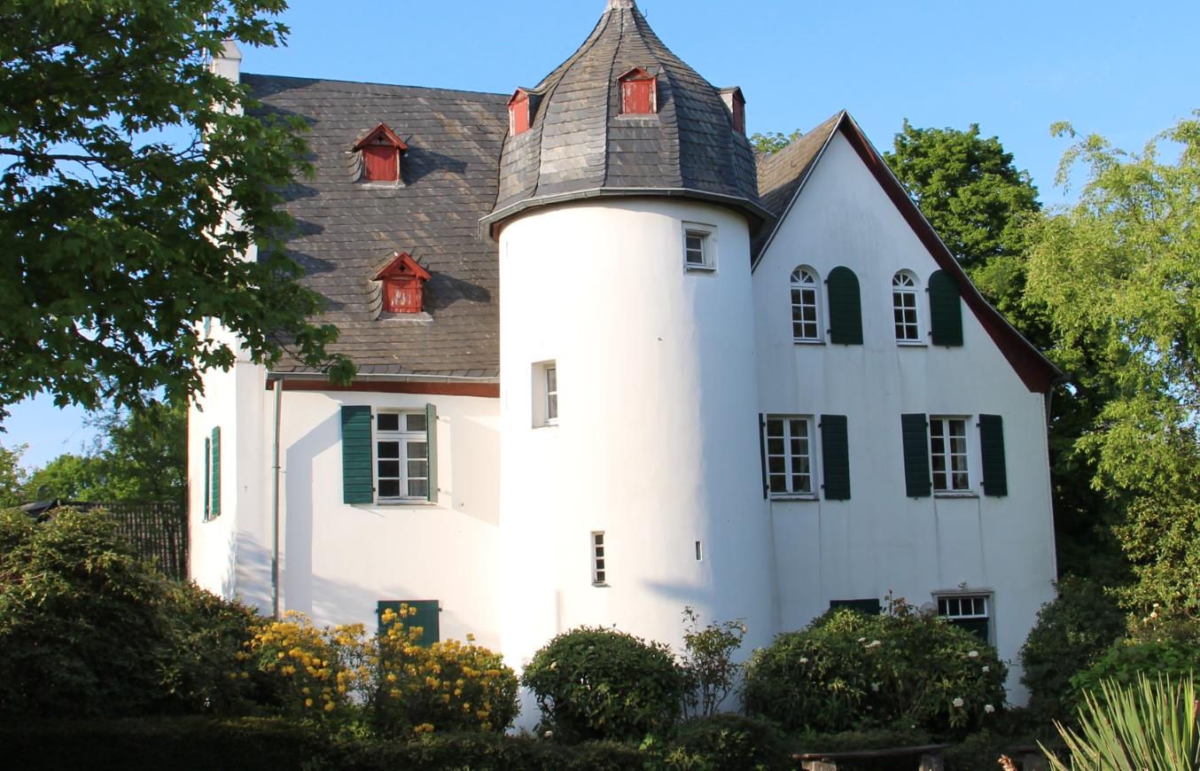 Friedenberger Hof mit Bäumen und blauem Himmel