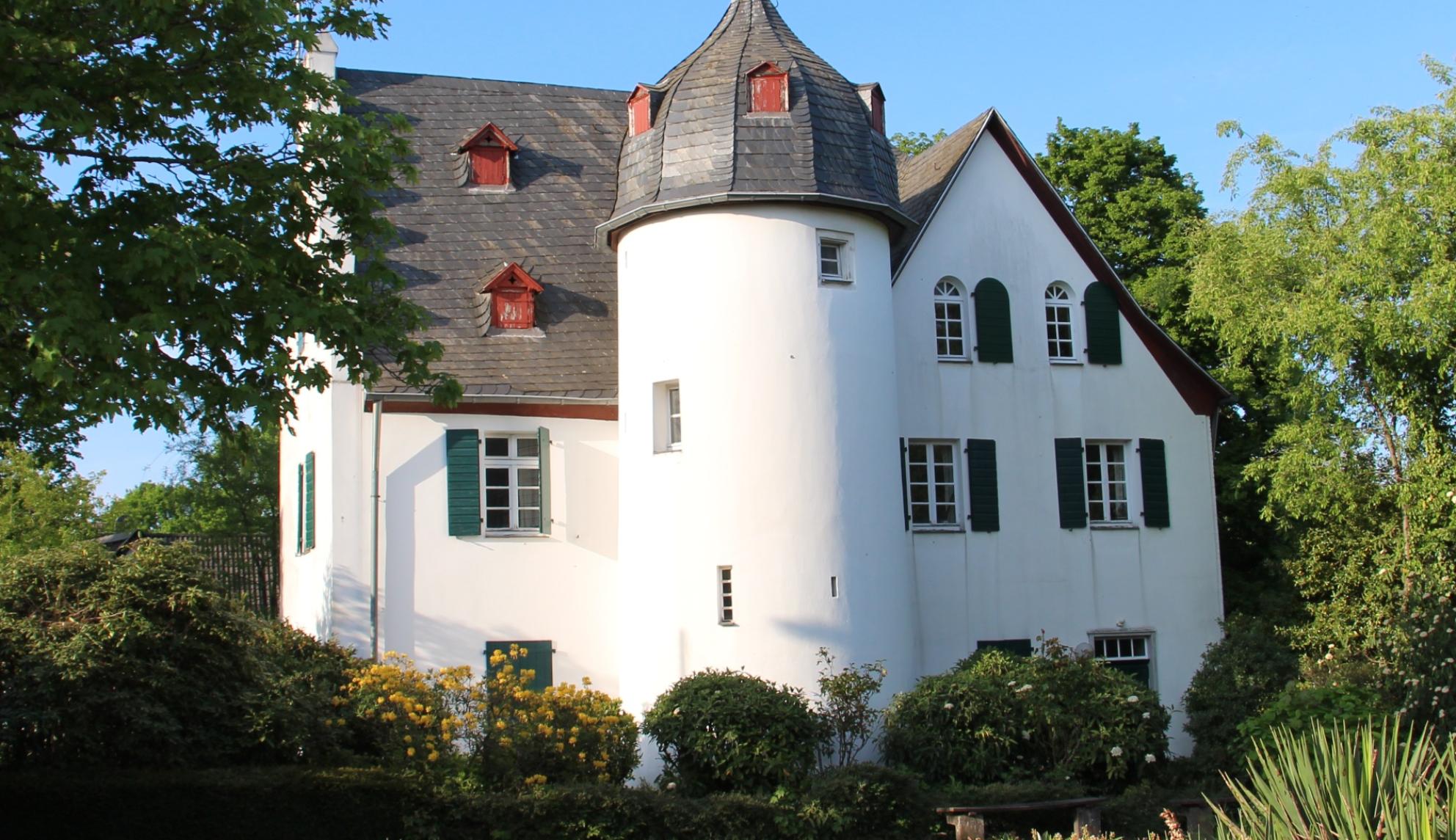 Friedenberger Hof mit Bäumen und blauem Himmel