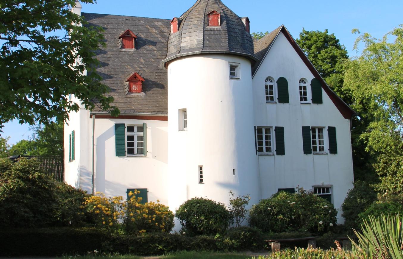 Friedenberger Hof mit Bäumen und blauem Himmel