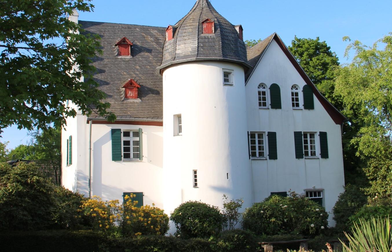 Friedenberger Hof mit Bäumen und blauem Himmel
